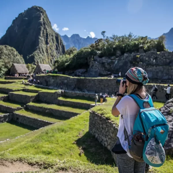 Traveler photographing Machu Picchu during clear peak-season weather while researching the best time to visit Machu Picchu 2026.