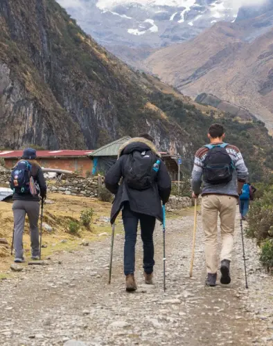Hiking Through the Andean Mountains Hikers walking along a mountain trail near an Andean village