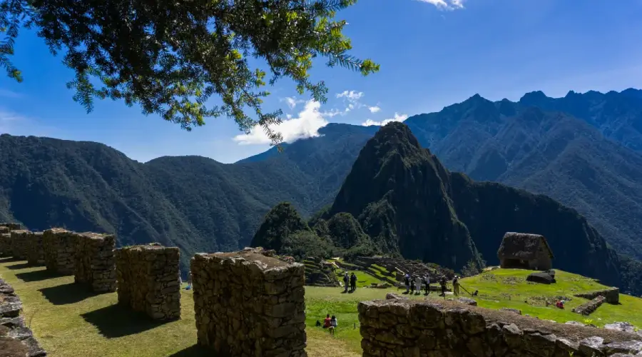 Panoramic view of Machu Picchu surrounded by Andean mountains under clear blue sky