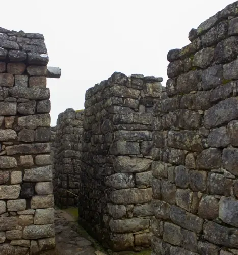 Machu Picchu stone path Stone pathway inside Machu Picchu surrounded by ancient walls and mist