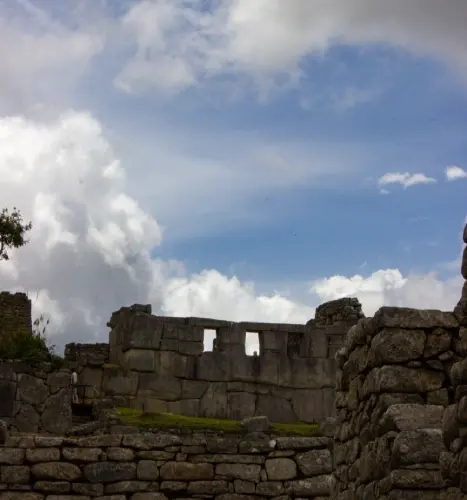 Inca stone architecture at Machu Picchu Stone walls and ancient structures inside Machu Picchu under a cloudy sky