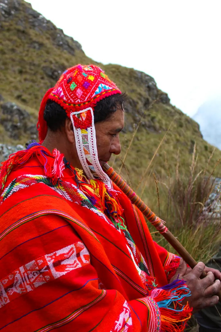 Andean musician playing traditional flute in the mountains of Cusco, Peru