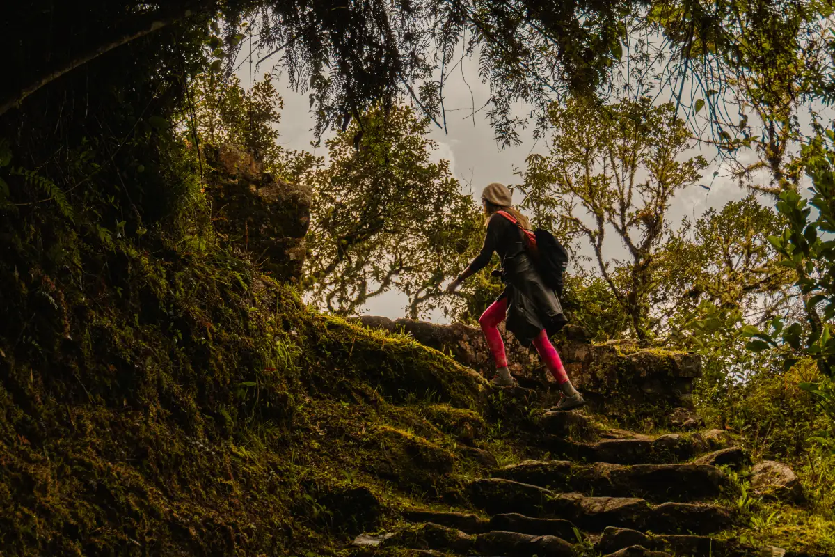 Traveler demonstrating how to prepare for the Inca Trail by hiking uphill with a backpack in the Peruvian Andes