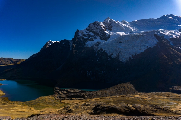 High-altitude glacier and turquoise lake surrounded by dramatic mountains in the Ausangate region