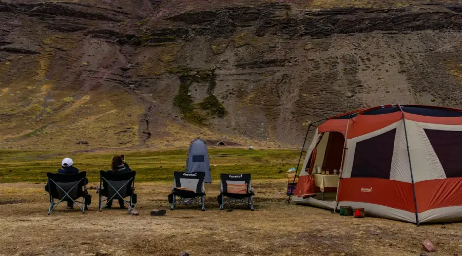 Relaxing at Camp in the Andes Travelers relaxing beside a mountain camp surrounded by the remote landscapes of the Peruvian Andes