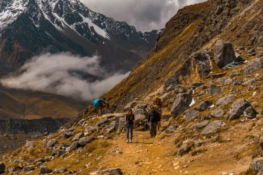 Hikers walking along a rocky mountain trail in the Salkantay region of Peru