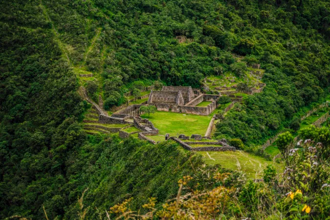 Ancient stone structures and terraces of the Choquequirao archaeological site surrounded by lush mountains