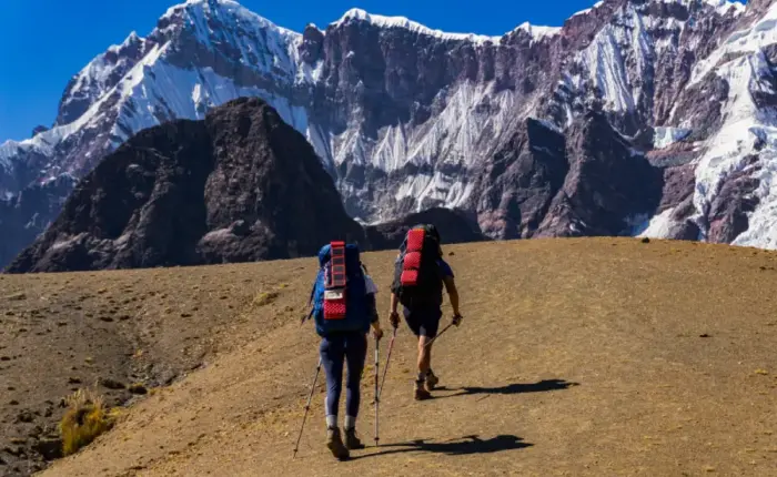 Two hikers wearing trekking clothing and carrying backpacks in the high mountains of Peru