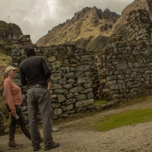 Exploring Inca Stone Ruins Travelers exploring ancient Inca stone ruins in the Andes