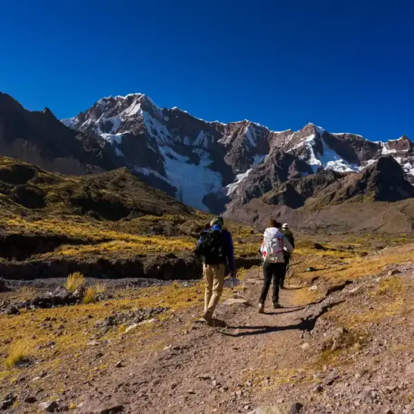 What to Pack for the Ausangate Trek: hikers carrying essential gear through the Peruvian Andes