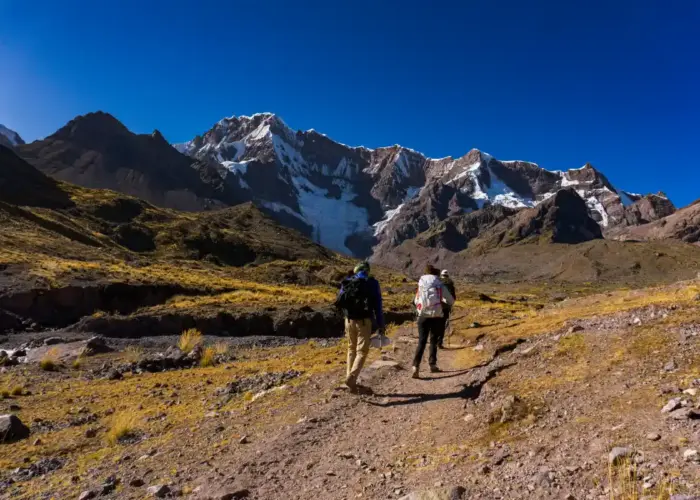 What to Pack for the Ausangate Trek: hikers carrying essential gear through the Peruvian Andes