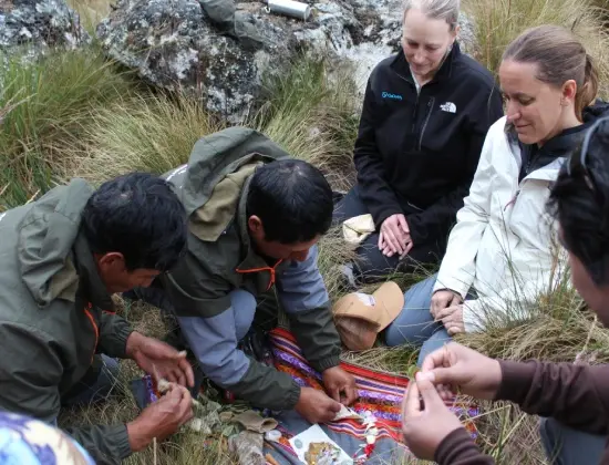 Travelers and local team members participating in an outdoor Andean cultural activity.
