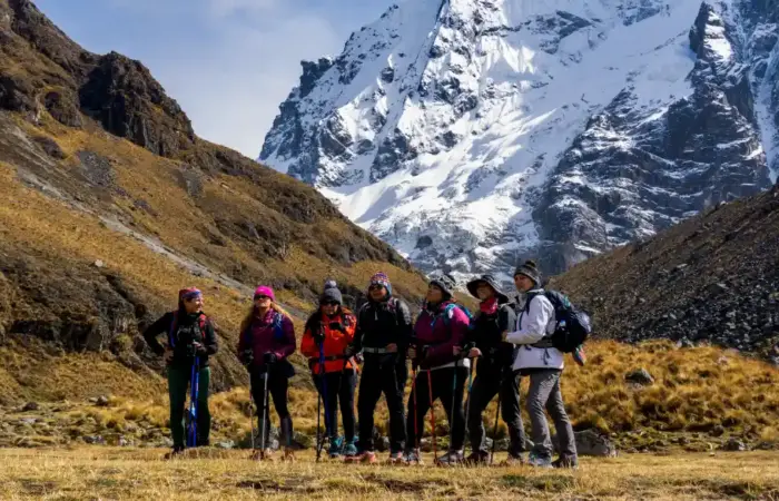 Hikers trekking beneath the snow-capped Salkantay Mountain in Peru