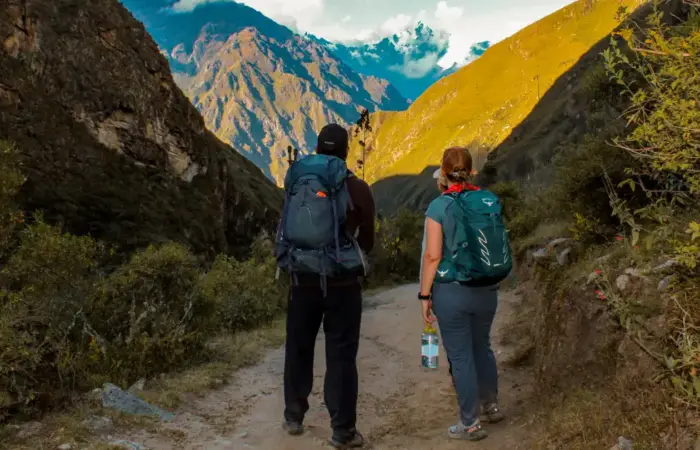 Peru trekking booking guide featuring two hikers walking along a mountain trail in the Andes