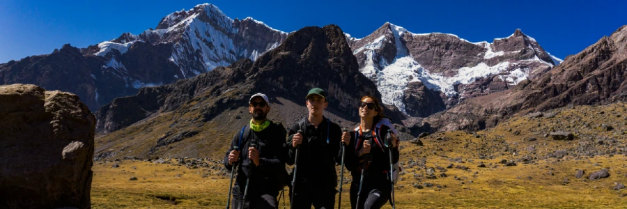 Trekkers exploring a high-altitude mountain landscape in the Peruvian Andes.