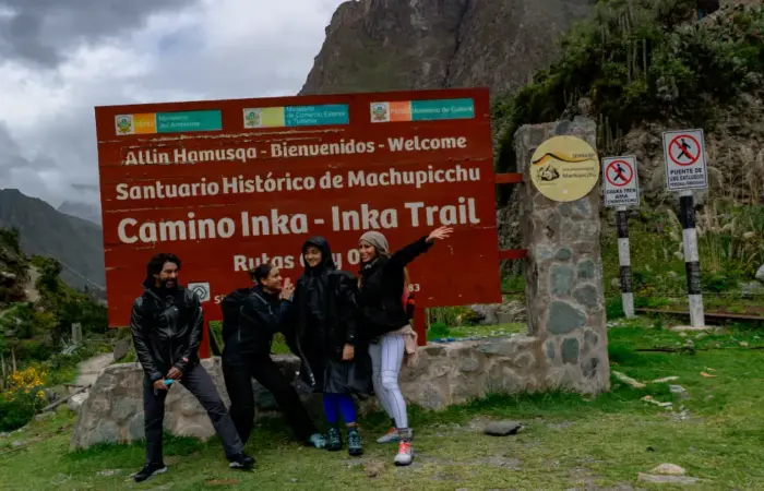 Trekking permits in Peru: travelers beside the official Inca Trail welcome sign near Machu Picchu